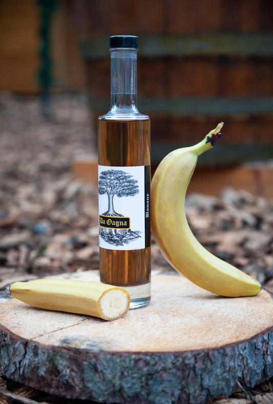 Flasche Da Oagna Bananen-Likör mit frischen Bananen und natürlichem Hintergrund