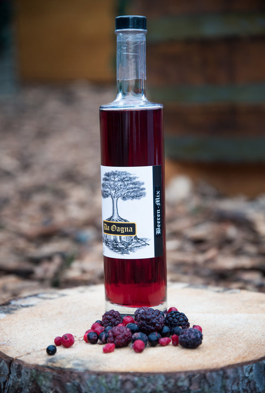 Da Oagna Beeren-Mix-Likör mit frischen Beeren, Zimtstange und Zitronenscheibe auf Naturtisch