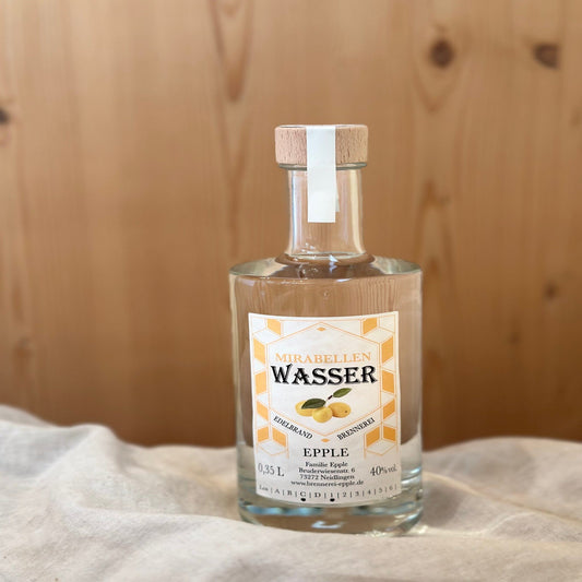 Mirabellenwasser in einer Glasflasche von Schnapsvielfalt. Klarer Brand aus sonnengereiften Mirabellen mit zartem Fruchtaroma, ideal für Liebhaber edler Obstbrände.