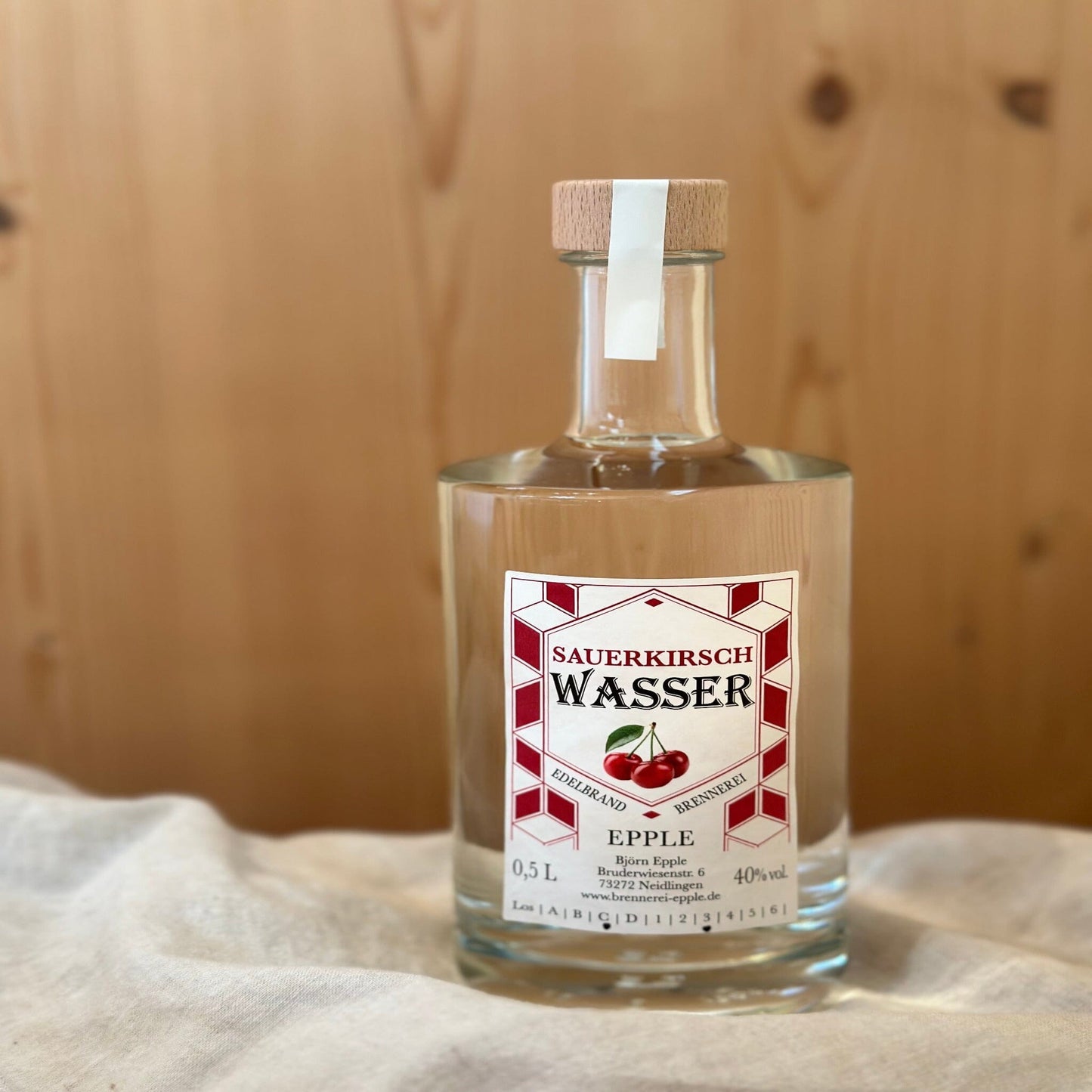 Sauerkirschwasser in einer Glasflasche von Schnapsvielfalt. Klarer Brand aus reifen Sauerkirschen mit intensivem Kirscharoma und erfrischendem Geschmack, ideal für Liebhaber fruchtiger Spirituosen.