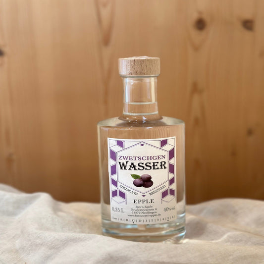 Zwetschgenwasser in einer Glasflasche von Schnapsvielfalt. Klarer Brand aus reifen Zwetschgen mit intensivem Fruchtaroma und harmonischem Geschmack, ideal für Liebhaber traditioneller Obstbrände.